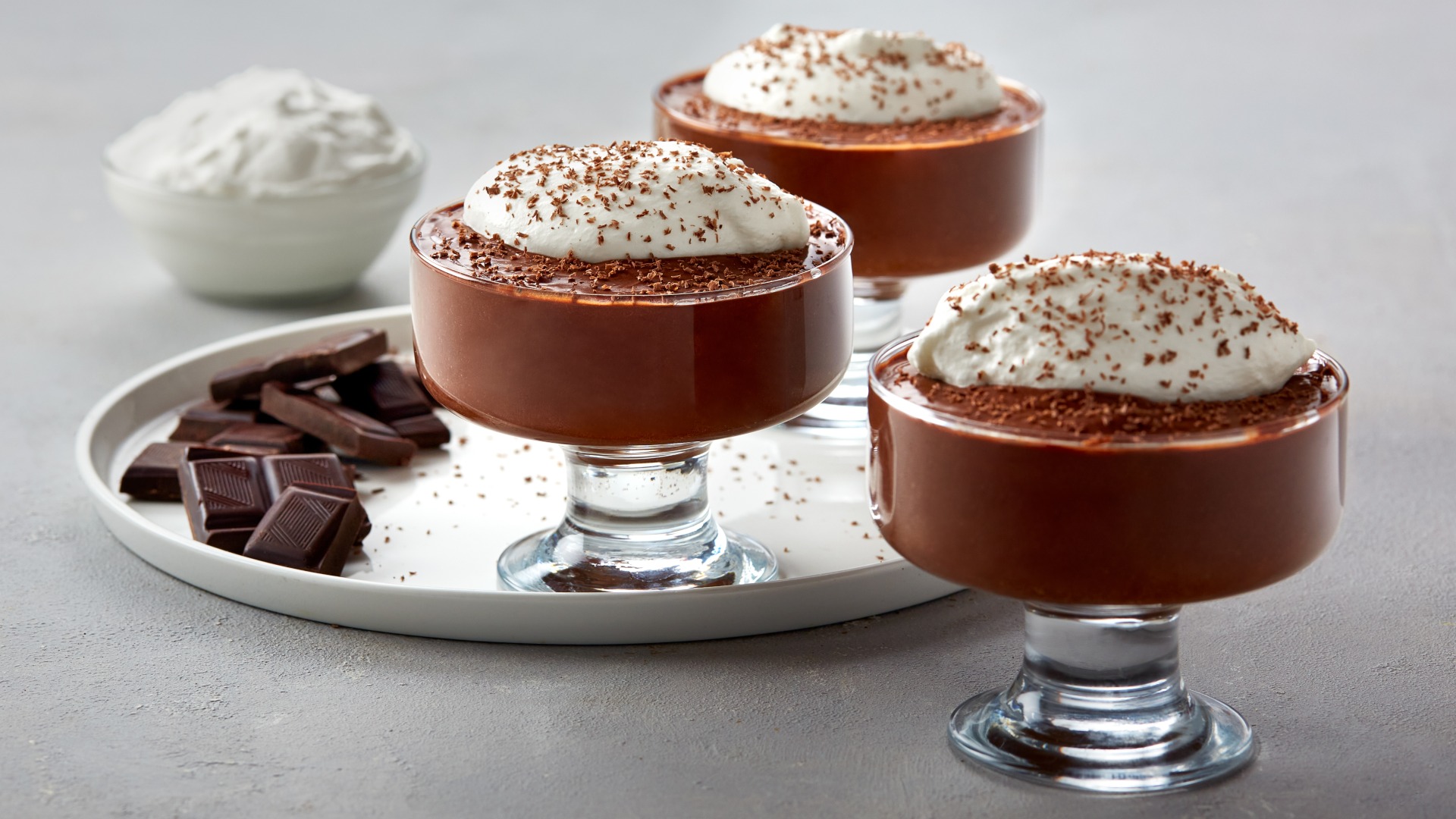 Chocolate mousse in a serving dish, topped with whipped cream. 