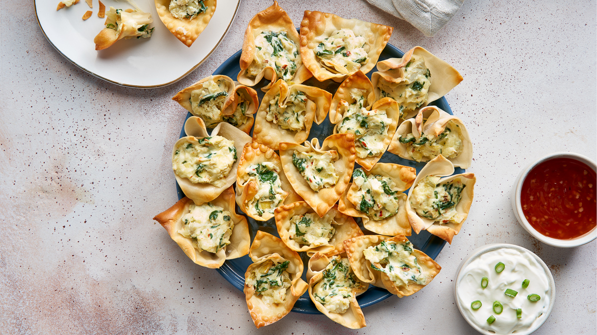 Dark blue plate with 16 mini spinach and artichoke wonton cups covering the whole plate.