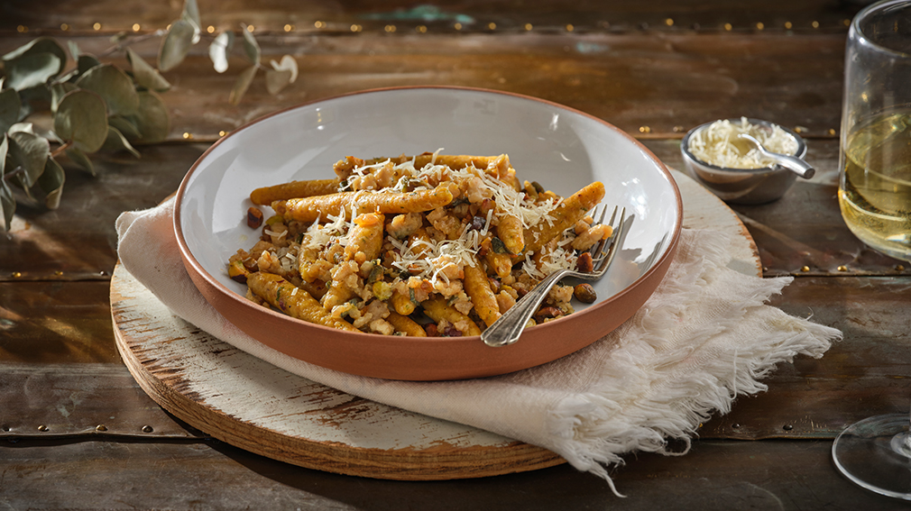 A pasta bowl is filled with hand-rolled cheese noodles with turkey pistachio sage butter.