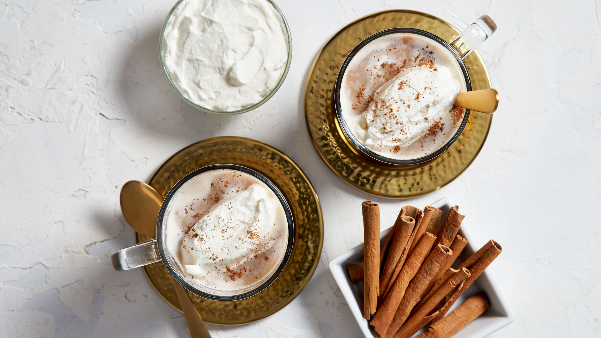 Chai latte with a side of cinnamon sticks and cream 